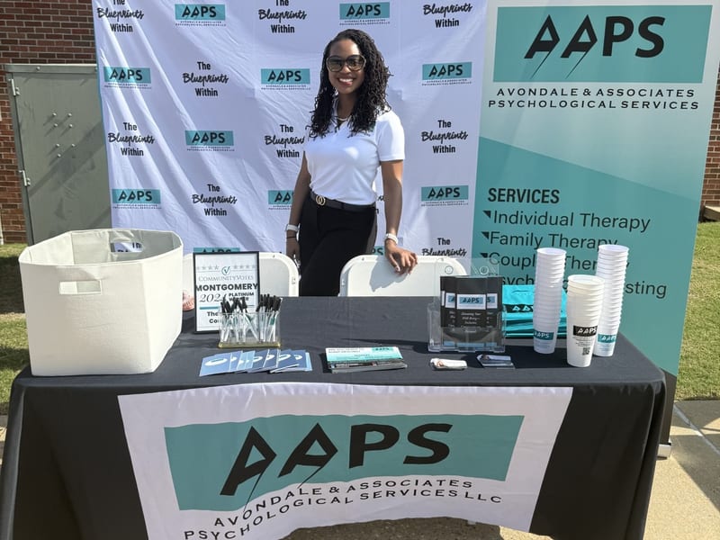 AAPS community event booth with Dr. Amanda Lewis-Yarbrough and branded signage