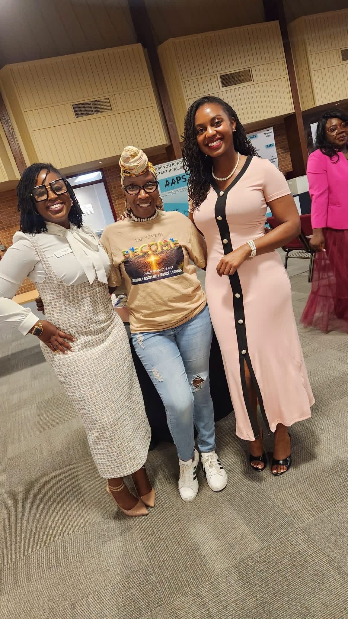 Three women posing together at an AAPS community event